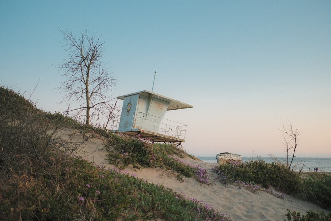 Lifeguard stand on a sandy beach with ocean background