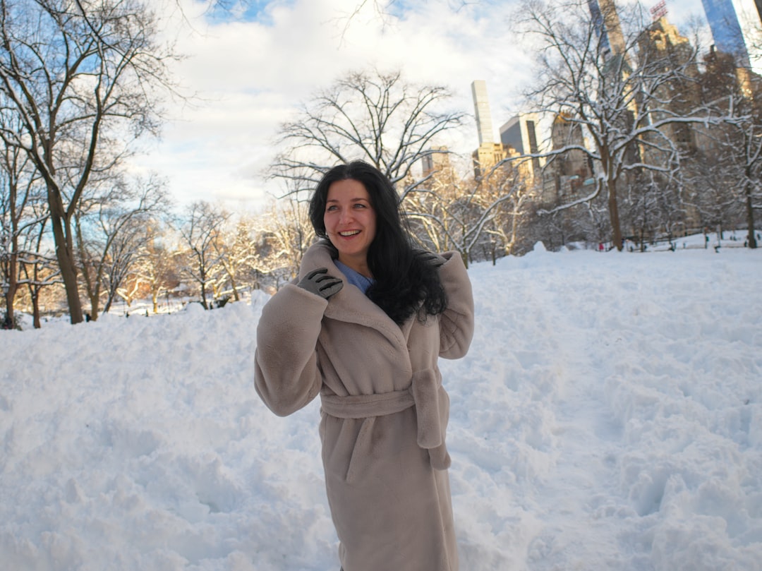 A smiling woman in a coat in the snow