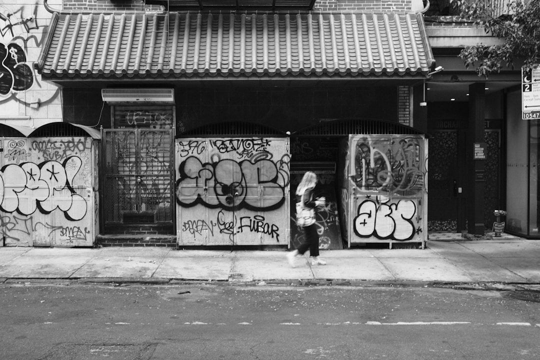 a person standing in front of a building with graffiti on it
